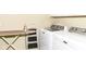 Well-lit laundry room with white washer and dryer, ironing board and handy step stool at 4039 Amaryllis Dr, Plainfield, IN 46168