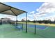 Outdoor pickleball court with shaded seating and green and blue playing surface at 4039 Amaryllis Dr, Plainfield, IN 46168