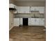 An updated kitchen features white cabinets, granite countertops, and wood grain flooring at 41 S Warman Ave, Indianapolis, IN 46222