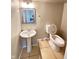Small bathroom with pedestal sink, toilet, neutral paint and decorative mirror at 4144 Richelieu Rd, Indianapolis, IN 46226