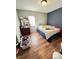 Bedroom with hardwood floors, a dresser with mirror, and a blue accent wall at 4144 Richelieu Rd, Indianapolis, IN 46226
