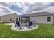 A serene backyard patio area with a charming fire pit, surrounded by comfortable seating and lush greenery at 4309 Viva Ln, Indianapolis, IN 46239