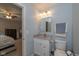 Well-lit bathroom with granite vanity, mirror, and gray towels next to the bedroom at 4309 Viva Ln, Indianapolis, IN 46239