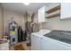 A utility room featuring a washer, dryer, water heater, and filtration system, all efficiently arranged for convenience at 4309 Viva Ln, Indianapolis, IN 46239