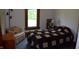 Bright bedroom featuring a traditional window, armchair, and comfortable quilt-covered bed at 4718 W Troy Ave, Indianapolis, IN 46241