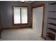 An empty bedroom with carpeted flooring, a window, closet, and built in shelving at 4718 W Troy Ave, Indianapolis, IN 46241