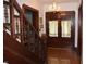 Classic entryway with wooden staircase, detailed woodwork and chandelier lighting creates a timeless welcome at 4718 W Troy Ave, Indianapolis, IN 46241