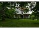 Charming two-story home featuring a welcoming front porch and mature trees in a spacious yard at 4718 W Troy Ave, Indianapolis, IN 46241