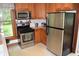 A traditionally styled kitchen with stainless steel appliances, a gas range, and light-colored cabinetry at 4718 W Troy Ave, Indianapolis, IN 46241