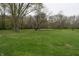 Expansive grassy yard surrounded by mature trees, providing a peaceful and private setting at 4718 W Troy Ave, Indianapolis, IN 46241