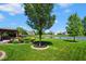 Expansive backyard offers lush green lawn, lake view, mature trees, landscaping and an outdoor living space at 5047 Skipping Stone Dr, Indianapolis, IN 46237