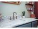 Close up bathroom vanity featuring a quartz countertop, bronze faucet, a sink, and bronze drawer hardware at 5047 Skipping Stone Dr, Indianapolis, IN 46237
