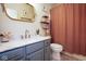 Bathroom featuring a vanity with bronze hardware, a decorative mirror and a rust-colored shower curtain at 5047 Skipping Stone Dr, Indianapolis, IN 46237