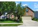 A well-maintained home with a lush green lawn, mature trees, and an attached two-car garage at 5047 Skipping Stone Dr, Indianapolis, IN 46237
