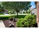 A scenic shot showcasing a well-manicured front yard with mature trees and a landscaped flower bed at 5047 Skipping Stone Dr, Indianapolis, IN 46237