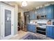Modern kitchen with stainless steel appliances, blue cabinets, and a pantry at 5047 Skipping Stone Dr, Indianapolis, IN 46237