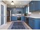 Modern kitchen with stainless steel appliances, blue cabinets, and a breakfast bar at 5047 Skipping Stone Dr, Indianapolis, IN 46237