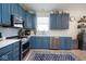 Updated kitchen with stainless steel appliances, blue cabinets, and quartz countertops at 5047 Skipping Stone Dr, Indianapolis, IN 46237