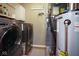 Functional laundry room and utility area, featuring a washer, dryer, and a hot water heater at 5047 Skipping Stone Dr, Indianapolis, IN 46237