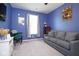 Inviting living room with blue walls, a comfortable sofa, a desk, and a window at 5047 Skipping Stone Dr, Indianapolis, IN 46237