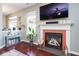 Cozy living room features a modern fireplace with a large screen TV above it and hardwood floors at 5047 Skipping Stone Dr, Indianapolis, IN 46237