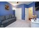 Comfortable living room featuring a gray couch, a closet, and blue painted walls at 5047 Skipping Stone Dr, Indianapolis, IN 46237