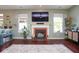 Inviting living room features a cozy fireplace, TV, and natural light from large windows at 5047 Skipping Stone Dr, Indianapolis, IN 46237