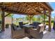 Covered outdoor living area offers comfortable seating and a view of the lake and meticulously maintained landscaping at 5047 Skipping Stone Dr, Indianapolis, IN 46237