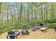 Back deck area with Adirondack chairs, seating, and a fire pit surrounded by greenery at 5948 Ridge Hill Way, Avon, IN 46123