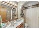 Bathroom featuring a marble vanity, wood cabinets, decorative wallpaper, and a shower tub combo at 5948 Ridge Hill Way, Avon, IN 46123