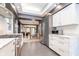 Open-concept kitchen featuring stainless steel appliances, marble counters, and seamless flow to the dining and living areas at 6167 Carrollton Ave, Indianapolis, IN 46220