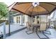 Outdoor patio with a seating area featuring a shade cover and a brick house background at 6167 Carrollton Ave, Indianapolis, IN 46220