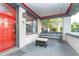 Charming front porch with a cozy porch swing and ottoman, red door, offering a relaxing outdoor space at 6167 Carrollton Ave, Indianapolis, IN 46220