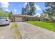 A single-story brick home with a driveway, lawn, and mature trees at 6191 Geneva St, Stilesville, IN 46180