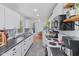 Modern kitchen with stainless steel appliances, tile backsplash, and open view to dining area at 6191 Geneva St, Stilesville, IN 46180