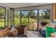 Enclosed sunroom with sliding glass doors offers views of the large backyard and outdoor wooden deck at 6191 Geneva St, Stilesville, IN 46180