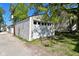 One-car garage, with white door, on gravel and grass, and a home in the background at 623 Orange St, Indianapolis, IN 46203