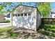 One-car garage, with white door, in grassy backyard, seen through trees and shade at 623 Orange St, Indianapolis, IN 46203