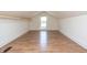 Finished attic featuring a window, neutral colors, and laminate flooring at 625 Dequincy St, Indianapolis, IN 46201