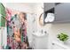 Stylish bathroom with a floral shower curtain, a white vanity, and modern shelving at 625 Dequincy St, Indianapolis, IN 46201