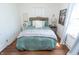Cozy bedroom featuring a queen bed with tufted headboard, soft bedding, and wood flooring at 625 Dequincy St, Indianapolis, IN 46201