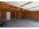 Spacious garage featuring exposed wood framing, concrete floor, and storage shelves at 625 Dequincy St, Indianapolis, IN 46201