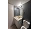 Bathroom with an aged vanity, standard mirror, and toilet; functional at 6432 Commons Dr, Indianapolis, IN 46254