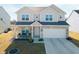 Charming two-story home with a brick and beige exterior, featuring a well-manicured lawn and attached two-car garage at 6903 Aster Dr, Pendleton, IN 46064