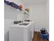 Functional laundry room featuring modern, front-loading washer and dryer and wire rack shelving at 6903 Aster Dr, Pendleton, IN 46064