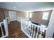 Upstairs hallway featuring hardwood floors, bright windows, and white railing at 6913 Thousand Oaks Ln, Indianapolis, IN 46214