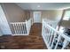 Hallway featuring hardwood floors, bright windows, and white railing at 6913 Thousand Oaks Ln, Indianapolis, IN 46214