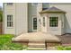 Back of the home featuring a raised wooden deck, exterior door, bay window, and neutral siding at 7023 Hartington Pl, Indianapolis, IN 46259