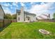 The home features a spacious backyard with lush lawn, a defined firepit area, and plenty of space for outdoor enjoyment at 7023 Hartington Pl, Indianapolis, IN 46259