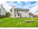 This home features a vast backyard that is ideal for outdoor activities, framed by lush greenery and open skies at 7023 Hartington Pl, Indianapolis, IN 46259